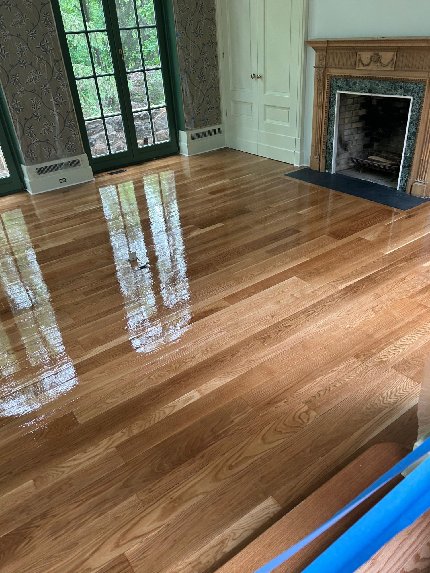 Living room floor refinishing with fresh gloss finish