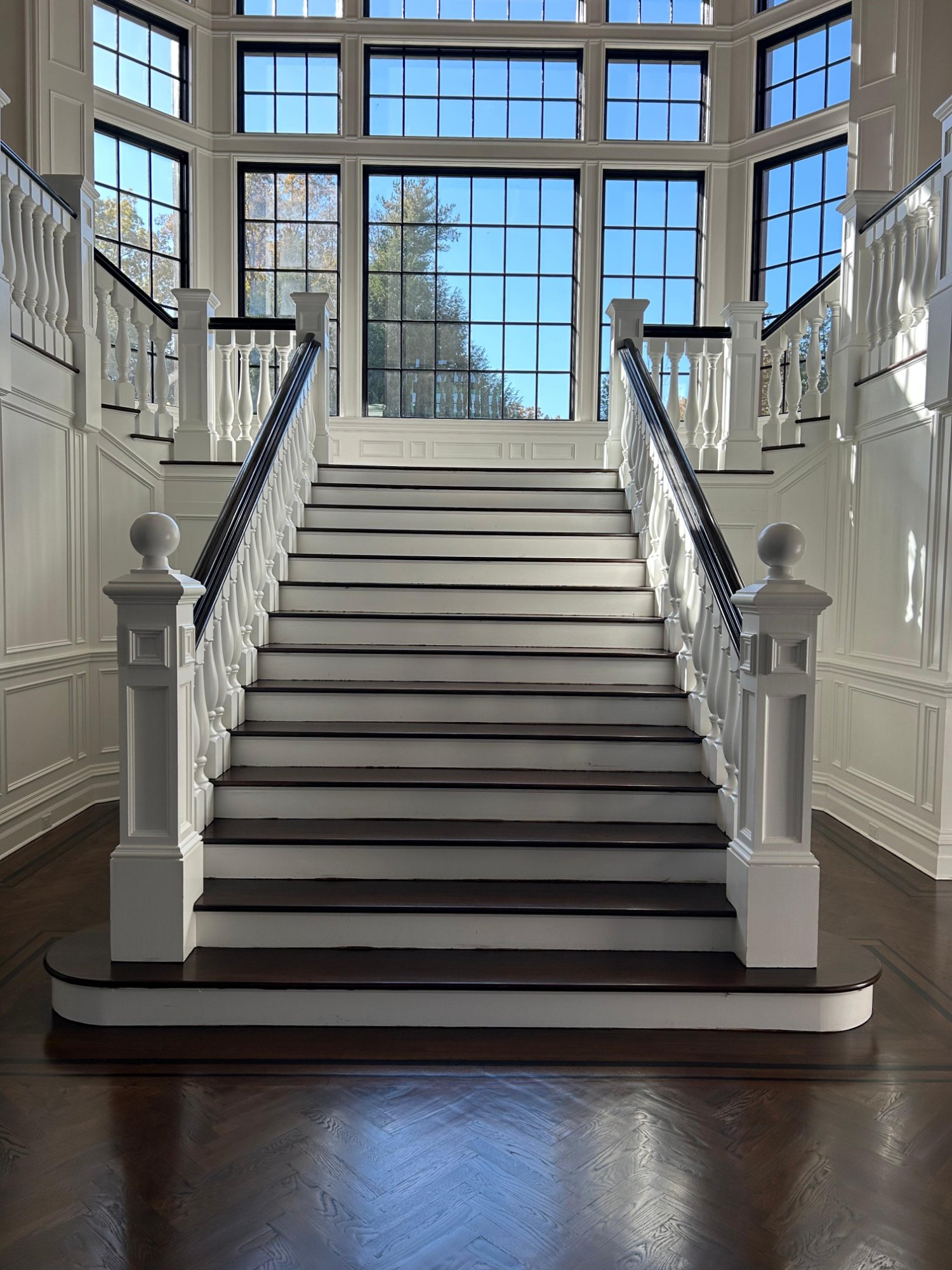 Grand staircase with herringbone hardwood floor refinish